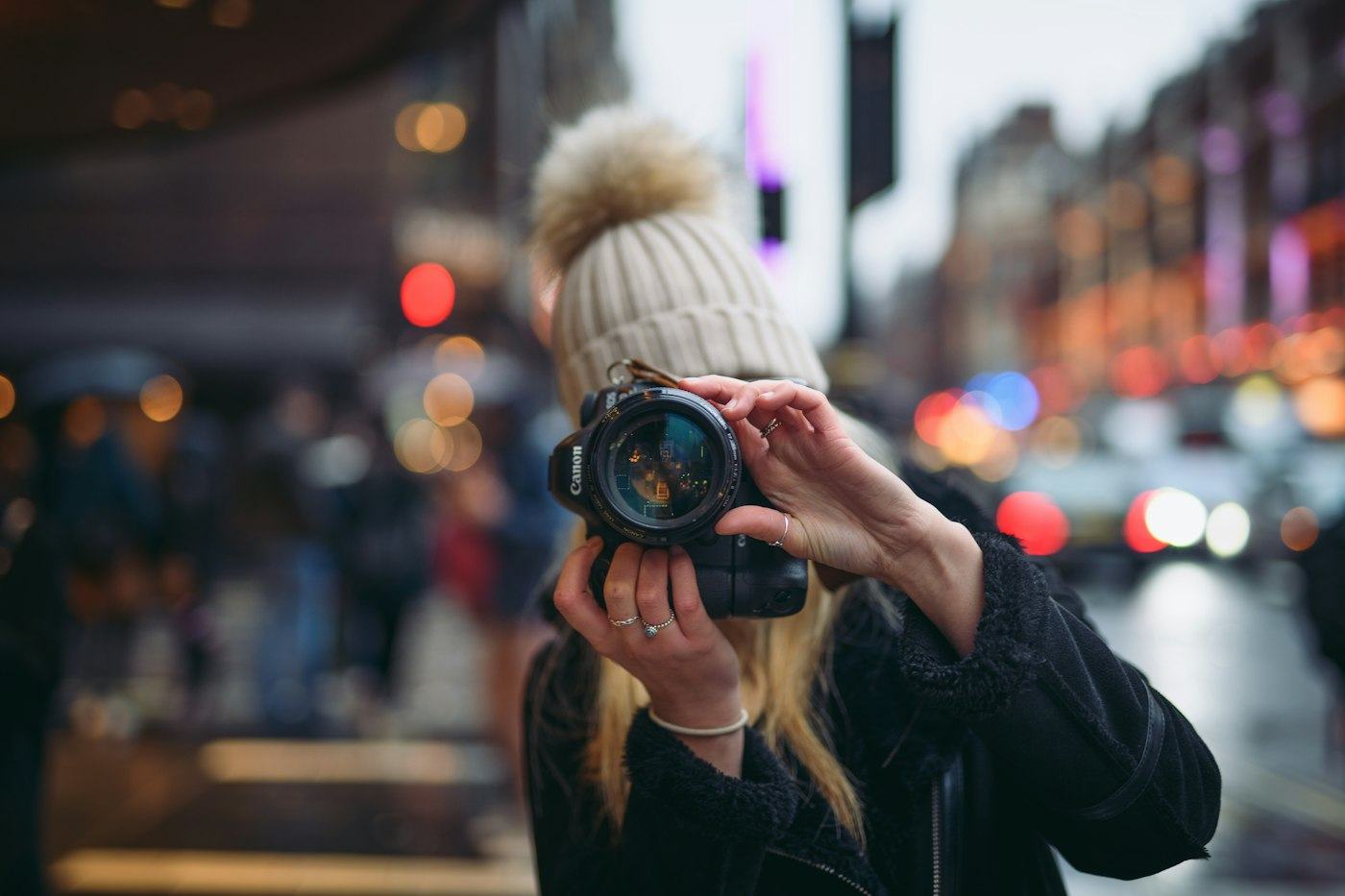 A young woman taking a photo on a London street